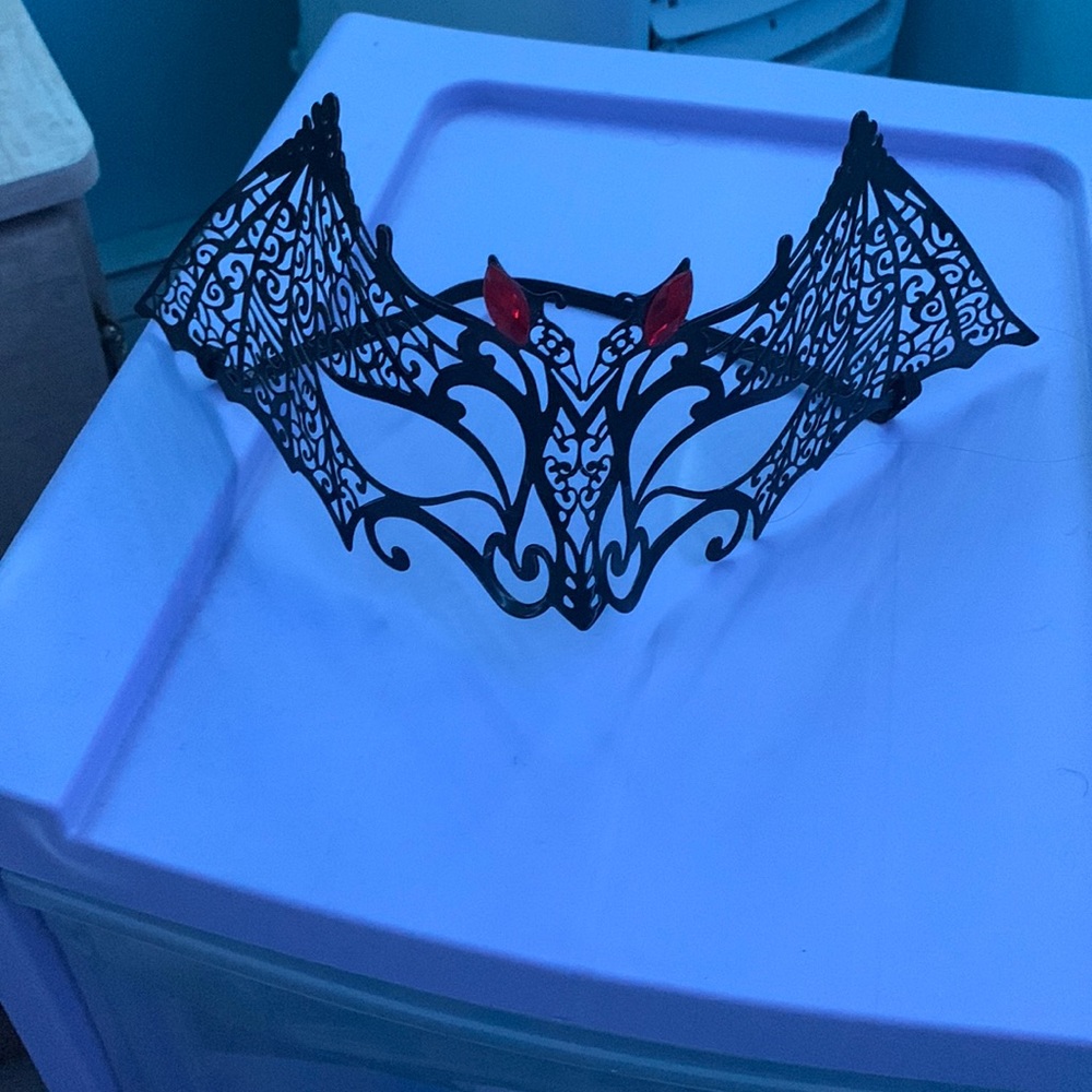 Halloween bat mask black and metal has red gems on it